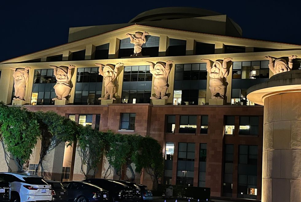A Walt Disney Studios building with carved statues of the Seven Dwarfs holding up the structure.