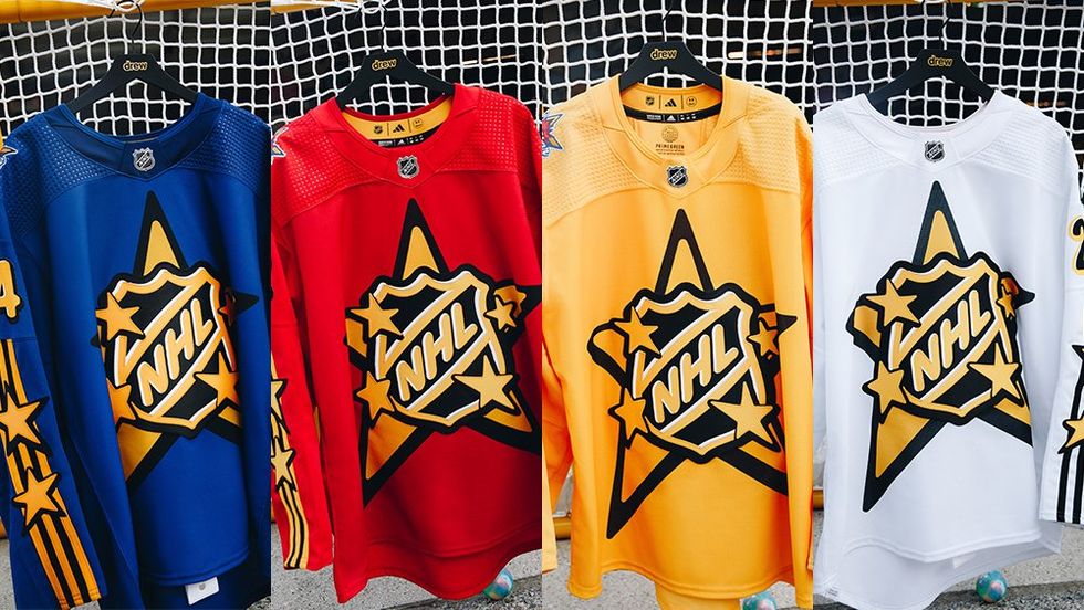Four jerseys, a blue one, red one, yellow one, and white one on hangers with a yellow star and the NHL logo on the front.