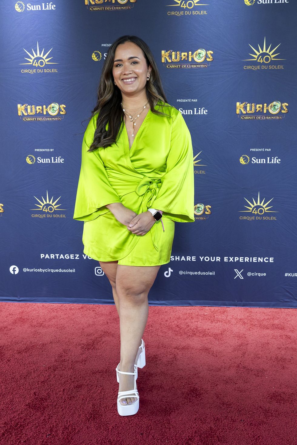 Kate Moya dans sa robe vert lime sur le tapis rouge de Kurios du Cirque du Soleil.