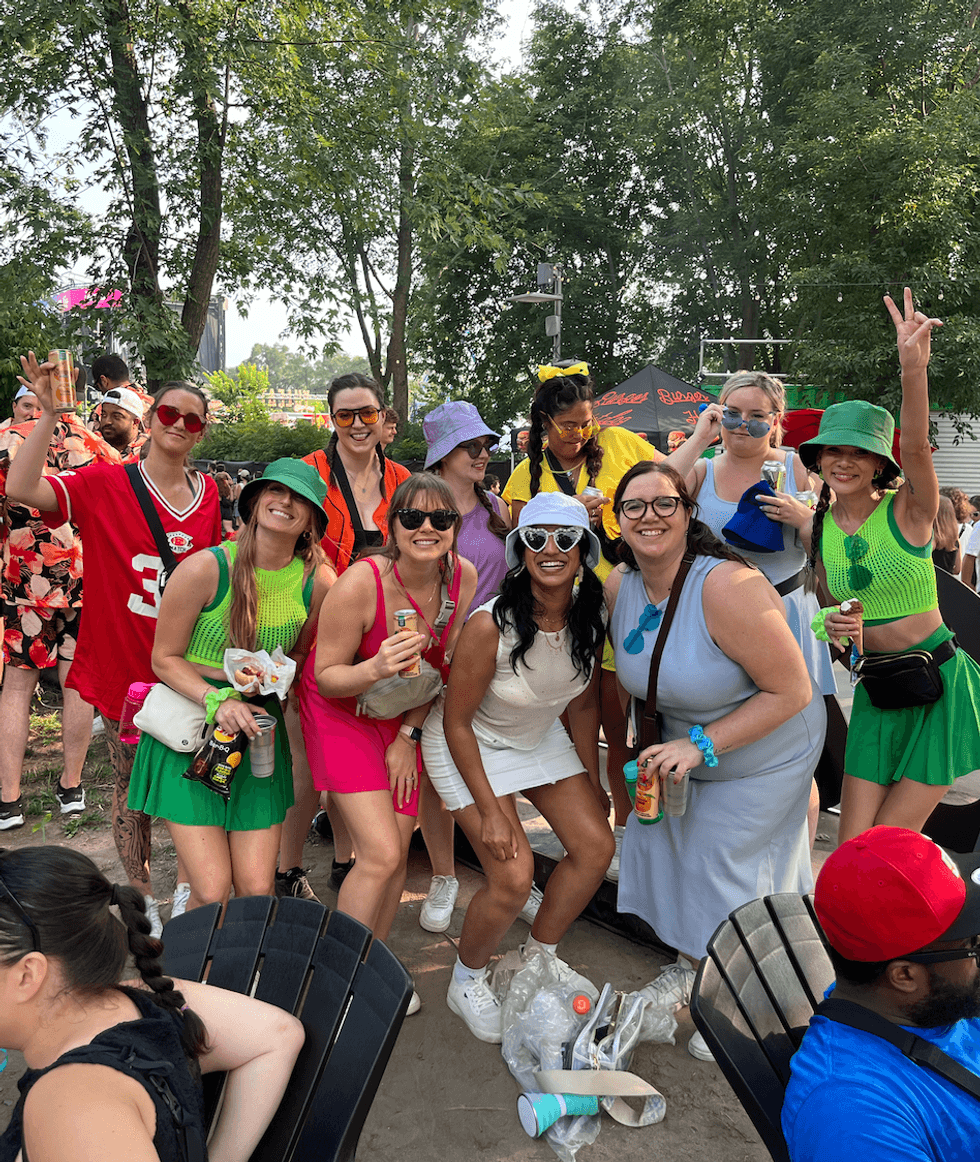 Une gang de festivali\u00e8res habill\u00e9es aux couleurs de l'arc-en-ciel.