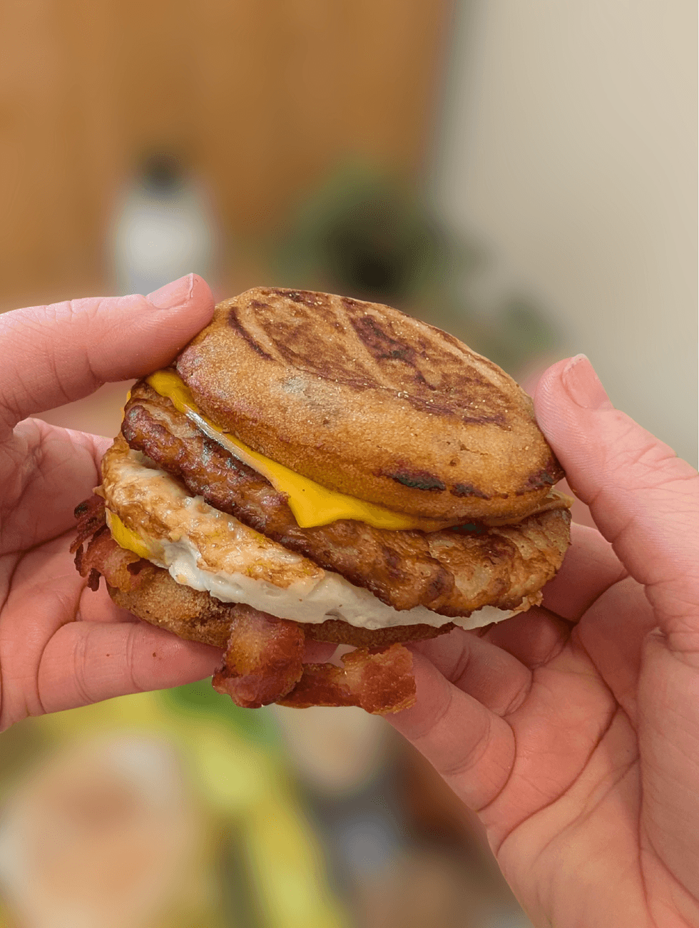 Two hands holding a Mighty McGriddles sandwich.