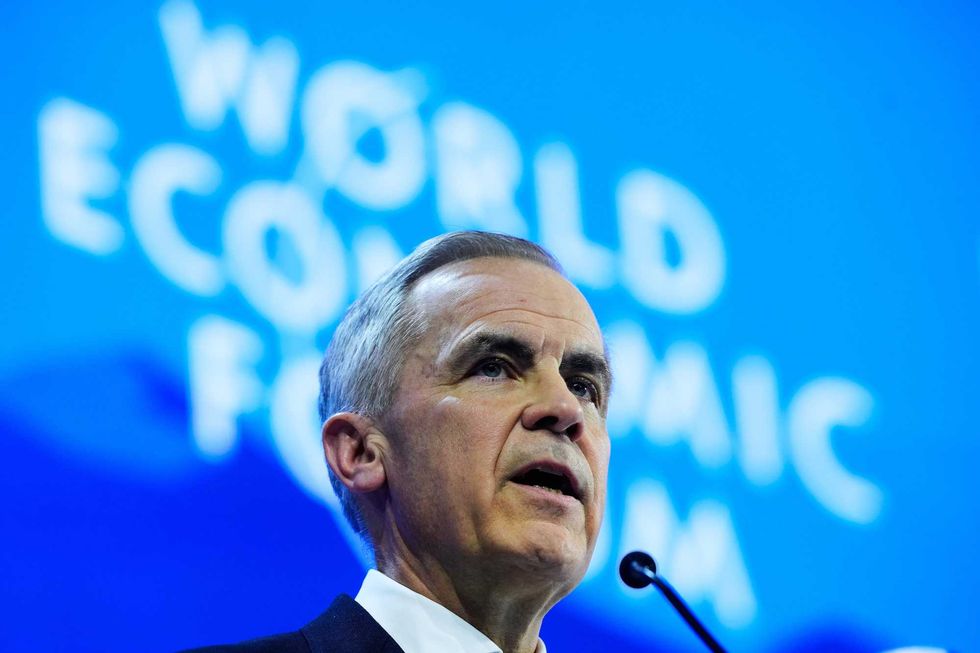 Mark Carney speaks at a podium in front of a backdrop reading "World Economic Forum."