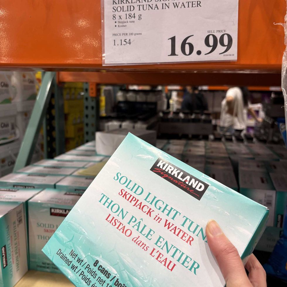 person holding pack of \u200b\u200bKirkland Signature canned tuna at Costco.