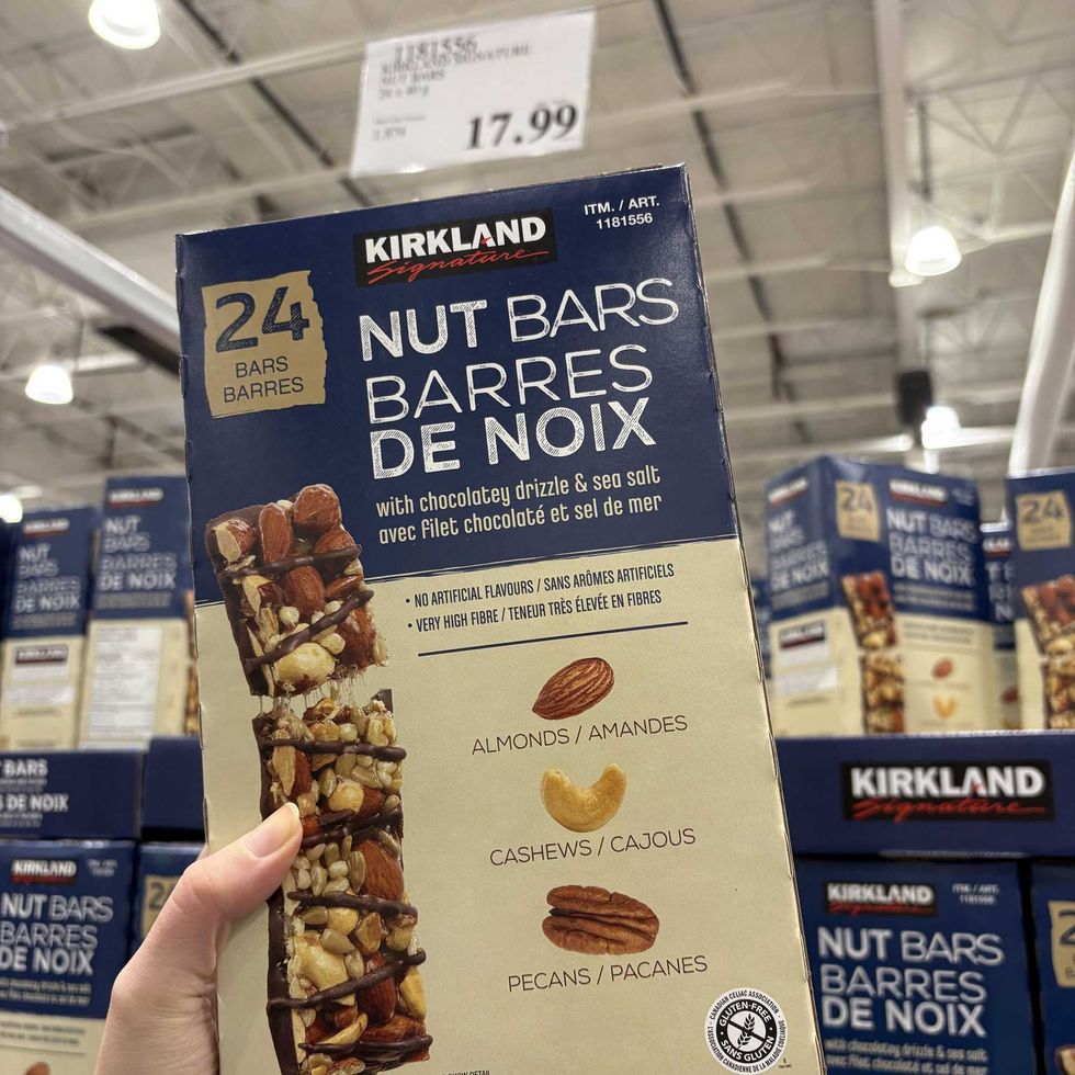 person holding box of \u200b\u200bKirkland Signature nut bars at Costco.
