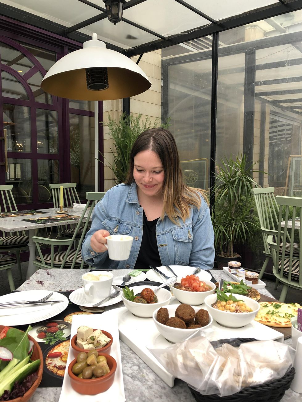 Valerie Durocher at a table with many plates of Middle Eastern food in Jordan.