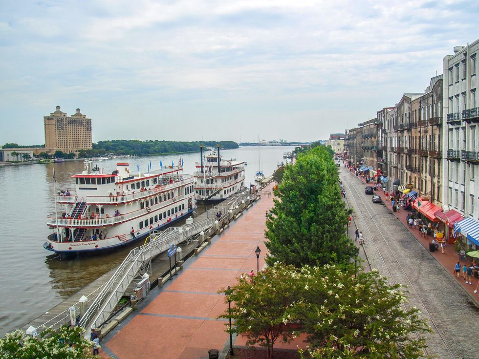 A river boat sails down River Street in Savannah, GA.
