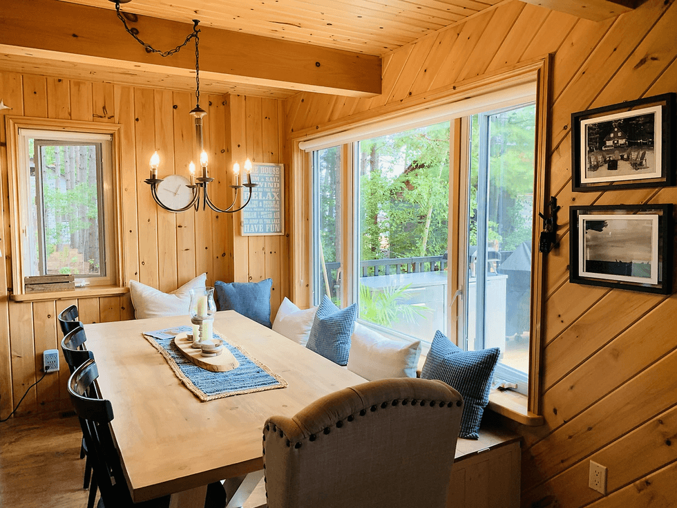 Kitchen table with seating for ten and BBQ grill in the backyard of the cottage.