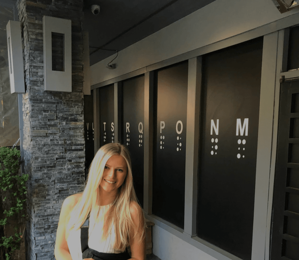 Ashley Harris standing in front of the restaurant.