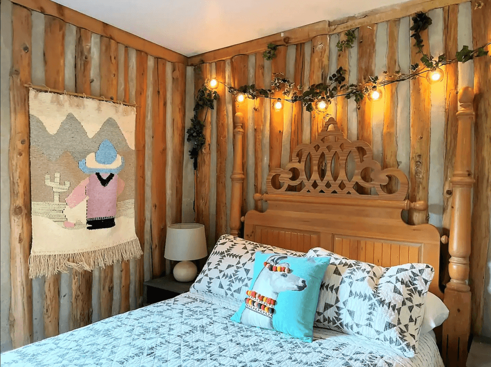 Bedroom with alpaca pillow and hanging lights.