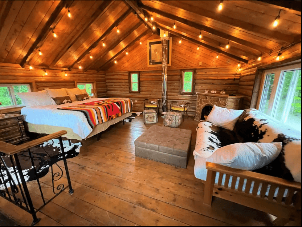 Bedroom with bed, couch, and fireplace.