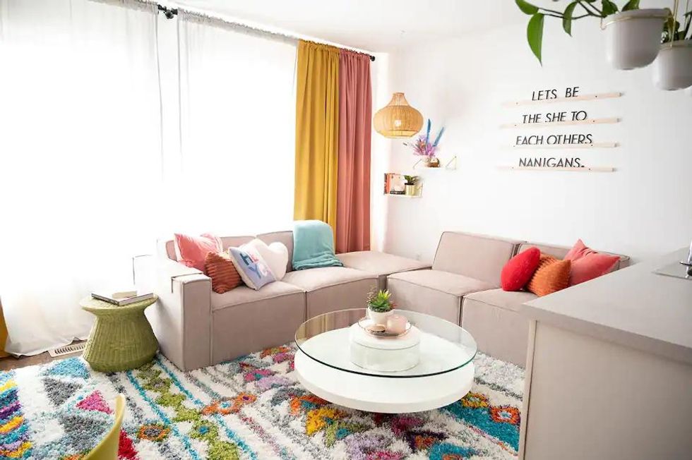 Cozy sectional couch and colourful decor in an Ontario Airbnb apartment.
