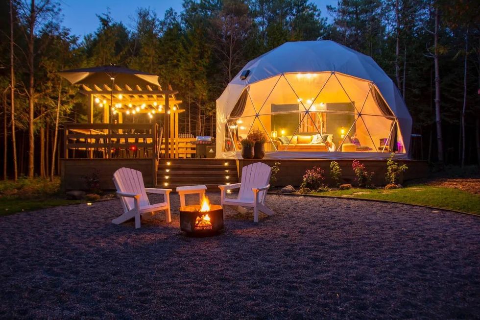 Glamping dome with a private fire pit and hot tub on a large deck.