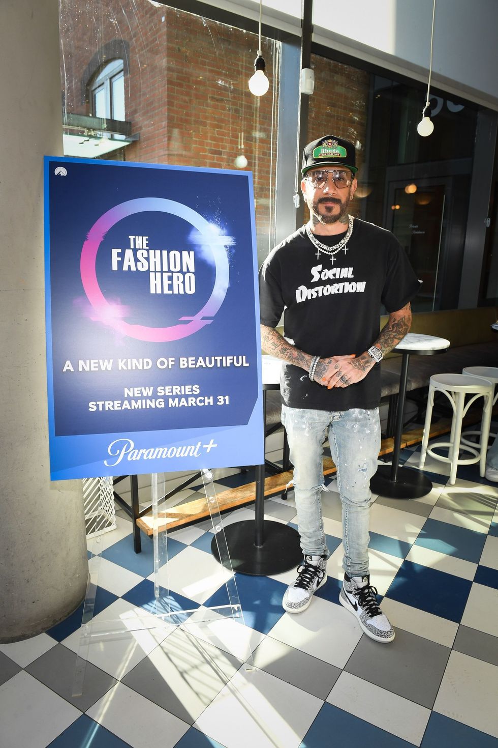AJ McLean standing alongside a poster about his upcoming TV series.