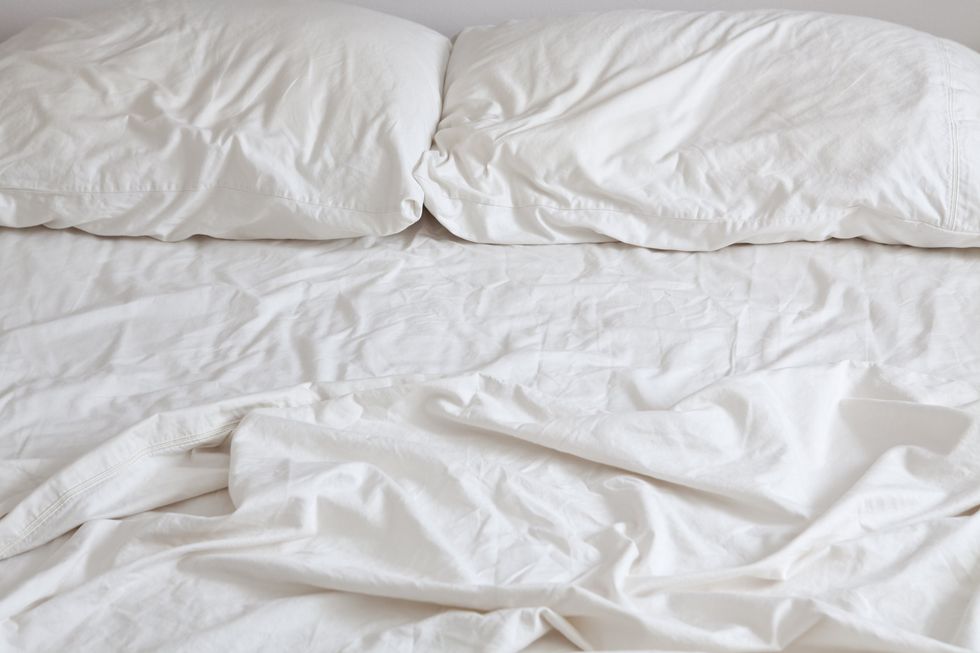 A bed with rumpled sheets.